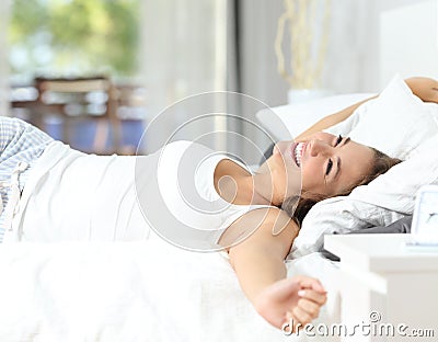 Girl waking up stretching arms on the bed Stock Photo
