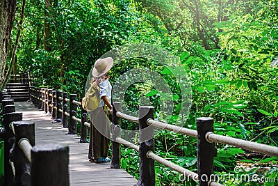 The Girl walking in the bridge and enjoying the tourism in through the mangrove forest. Waterfall Than Bok Khorani Nature Trail. Stock Photo