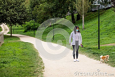 Girl walking her Pomerania female dog with a mask Stock Photo