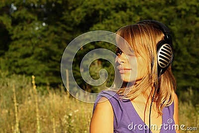 Girl walking and listening to music outdoors Stock Photo