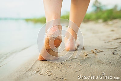 A girl walking on a sandy beach, leaving footprints in the sand. Beach trips. Loneliness. Happiness. Pacification Stock Photo