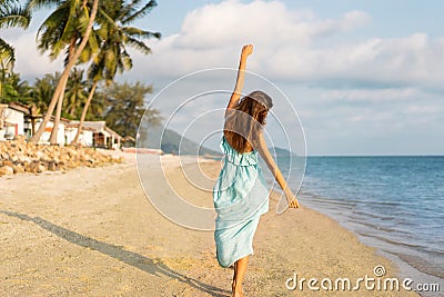 Girl walks on a tropical beach in a dres Stock Photo