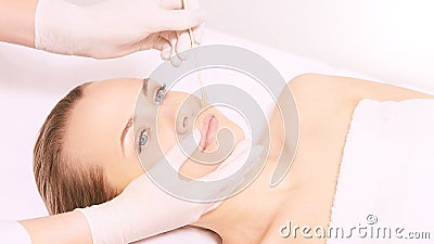 Girl wax lip at depilation center. Prfessional remove unwante hair on woman face Stock Photo