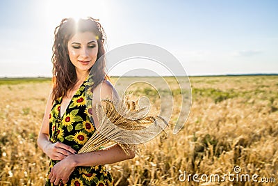 Girl in wheat field. bouquet of wheat in hand. sunset in nature Stock Photo