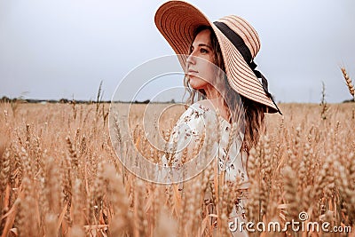 Girl wheat field summer. Happy young woman in sun hat in summer wheat field at sunset. Nature, summer holidays, vacation Stock Photo