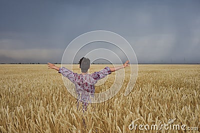 Girl in a wheat field before a thunderstorm Stock Photo