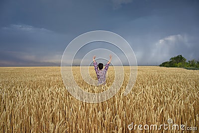 Girl in a wheat field before a thunderstorm Stock Photo