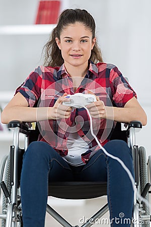 Girl in wheelchair holding computer joystick Stock Photo