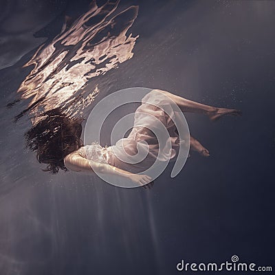 Girl with long hair swims underwater Stock Photo