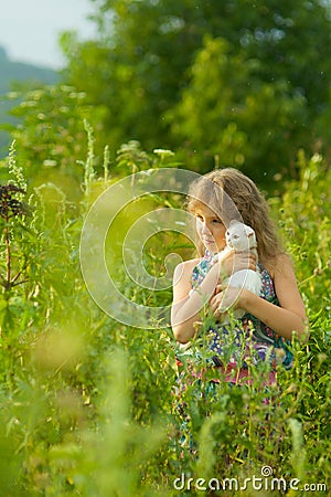 Girl with white pedigreed cat in her arms in a blue sundress Stock Photo