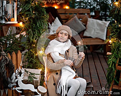 A girl in a white scarf with a Sparkler in a Christmas gazebo Stock Photo