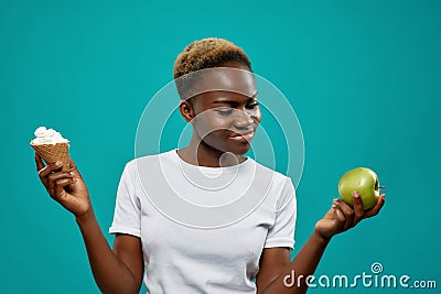 Girl in white shirt keeping healthy and unhealthy food Stock Photo
