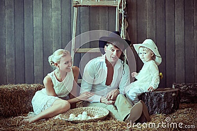 Girl in white sits and thoughtfully looks out the window with the child a beautiful Kiss family Easter eggs Stock Photo