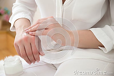 Girl in white smears hand cream. Hand care. Smear cream Stock Photo