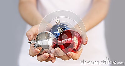 Girl in white t-shirt holding Christmas toy three ball. Silver, Stock Photo