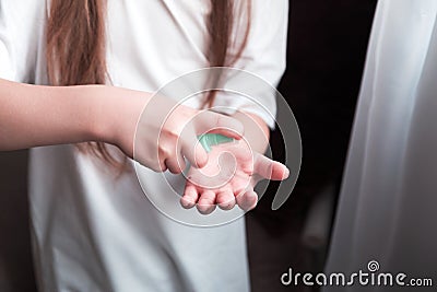 A girl in a white T-shirt uses an antiseptic hand spray Stock Photo