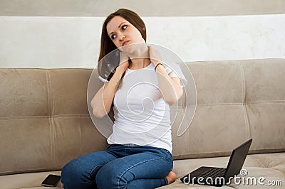 The girl worked at the computer and her neck ached. Pain in the neck Stock Photo