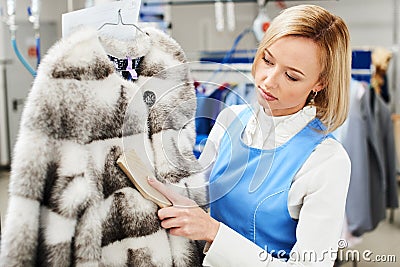 Girl worker performs dry Laundry, hand cleaning fur garments Stock Photo