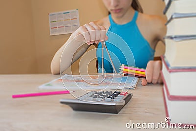 Girl is working with atlas at the wood table. Education and school concept - little student girl with many books Stock Photo