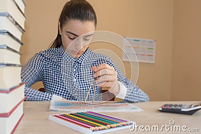 Girl is working with atlas at the wood table. Education and school concept - little student girl with many books Stock Photo