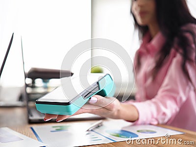 Girl in workplace holds banking mobile device Stock Photo