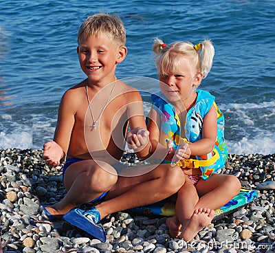 The girl of 3 years, the blonde, and her elder brother on a sea Stock Photo