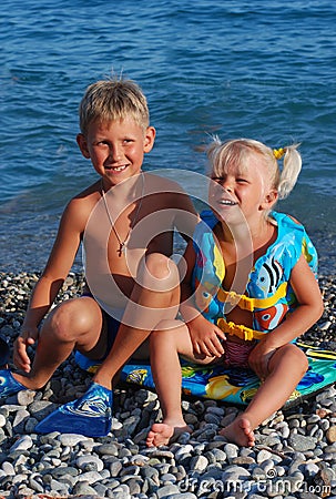 The girl of 3 years, the blonde, and her elder brother on a sea Stock Photo