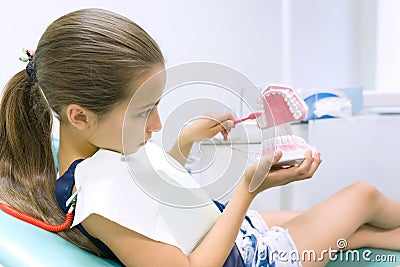 Girl 10 years old in dental chair, with tooth brush. Medicine, dentistry and healthcare concept Stock Photo