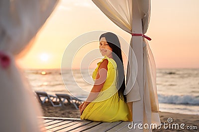 A girl in a yellow dress with long hair meets dawn Stock Photo