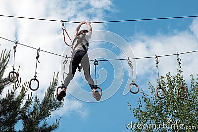 A girl ziplining in treetop adventure park. Healthy active lifestyle concept. Summer holidays. Editorial Stock Photo