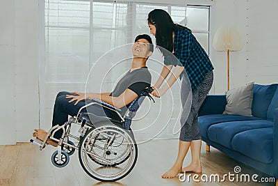 Girlfriend takes care of a disabled man with love in a warm home. Stock Photo