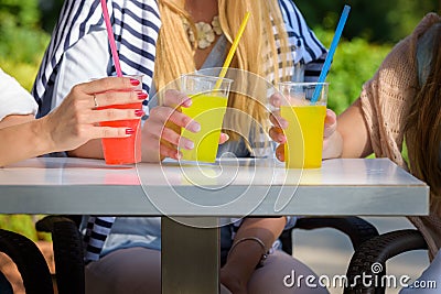 Girlfriends enjoying cocktails in an outdoor cafe, friendship concept Stock Photo