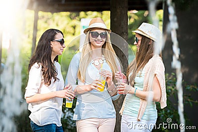 Girlfriends enjoying cocktails by a water fountain Stock Photo