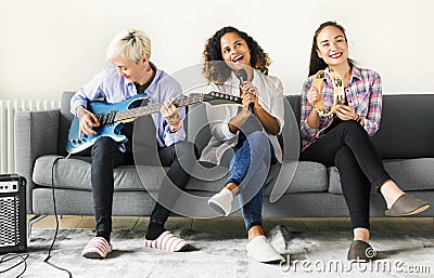 Girlfriends enjoying with singing and playing music Stock Photo
