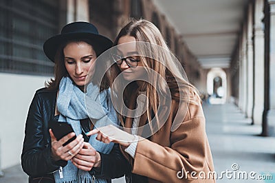 Girlfriends tourist using together smartphone mobile. Blogger hipster travels in europe city. Holiday friendship concept. Traveler Stock Photo