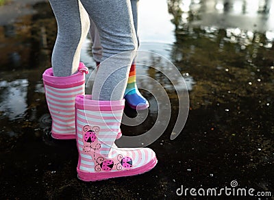 Girlie striped wellingtons in the puddle Stock Photo