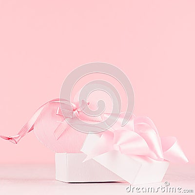 Girlish gentle Valentine days background - soft pastel pink heart with ribbon and bow on white wood board. Stock Photo