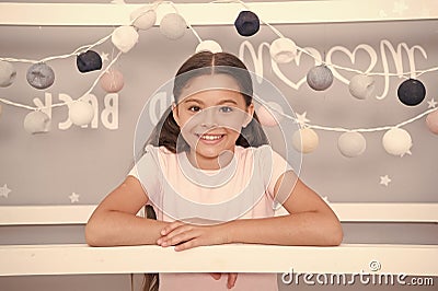 Girlish room. Child satisfied with bedroom interior. Girl with cute smile happy with her new bedroom garlands background Stock Photo