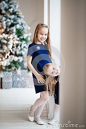 Girls in blue on background of Christmas tree Stock Photo