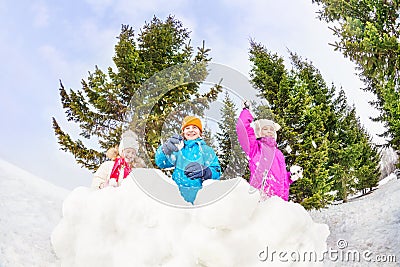 Girls and boy playing snowballs game in forest Stock Photo