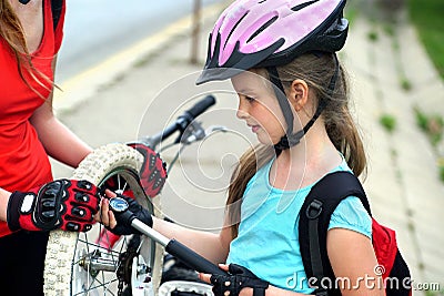 Girls children cycling Family pump up bicycle tire. Stock Photo