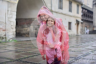 Girls children walking in the rain dressed in a raincoat Stock Photo