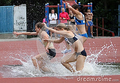 Girls compete in the 3.000 Meter Steeplechase Editorial Stock Photo