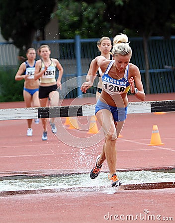 Girls compete in the 3.000 Meter Steeplechase Editorial Stock Photo