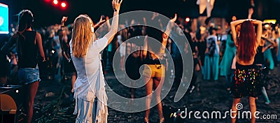 Girls enjoying summer night music party with DJ in outdoor nightclub. Stock Photo