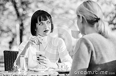 Girls friends drink coffee talk. Conversation women cafe terrace. Friendship friendly relations. Discussing rumors Stock Photo