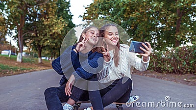 Girls girlfriends teenagers, summer park, photos smartphone, happy smiling, having fun playing. Selfie phone. Record Stock Photo