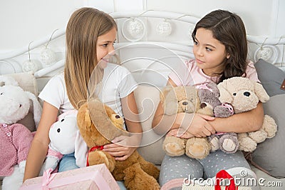 Girls kids wake up on christmas morning. Lets open christmas gifts. Sisters best friends with toys relax in bed with Stock Photo