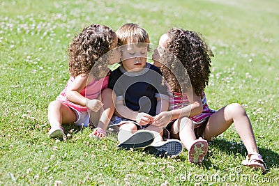 Girls kissing boy on cheek Stock Photo