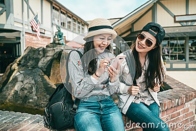 Girls laughing while sitting to the fountain Stock Photo